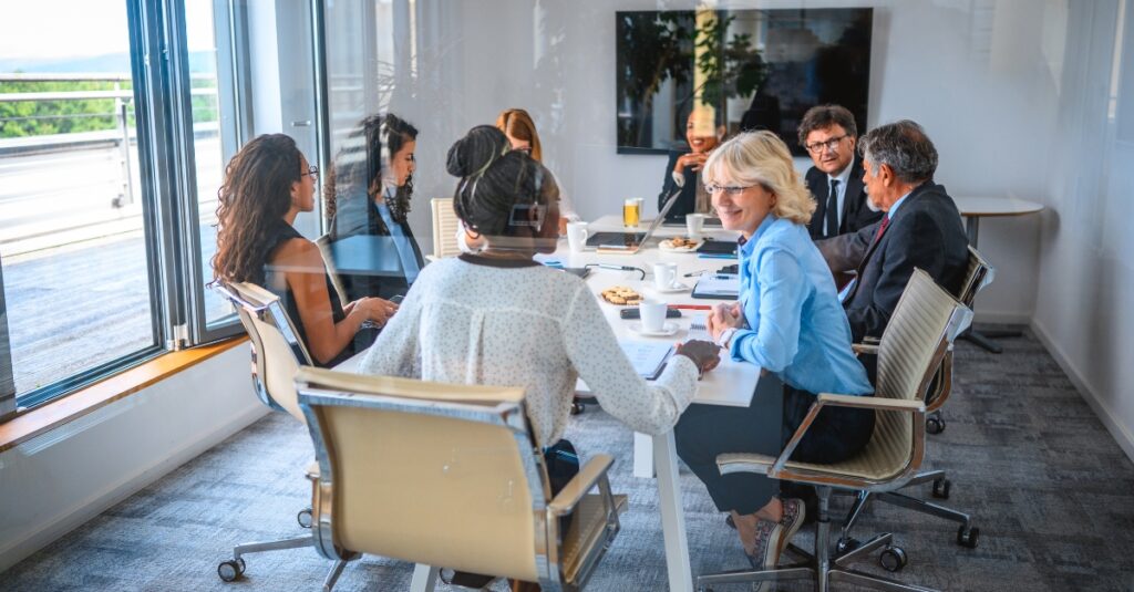 Diverse individuals sitting around a boardroom table